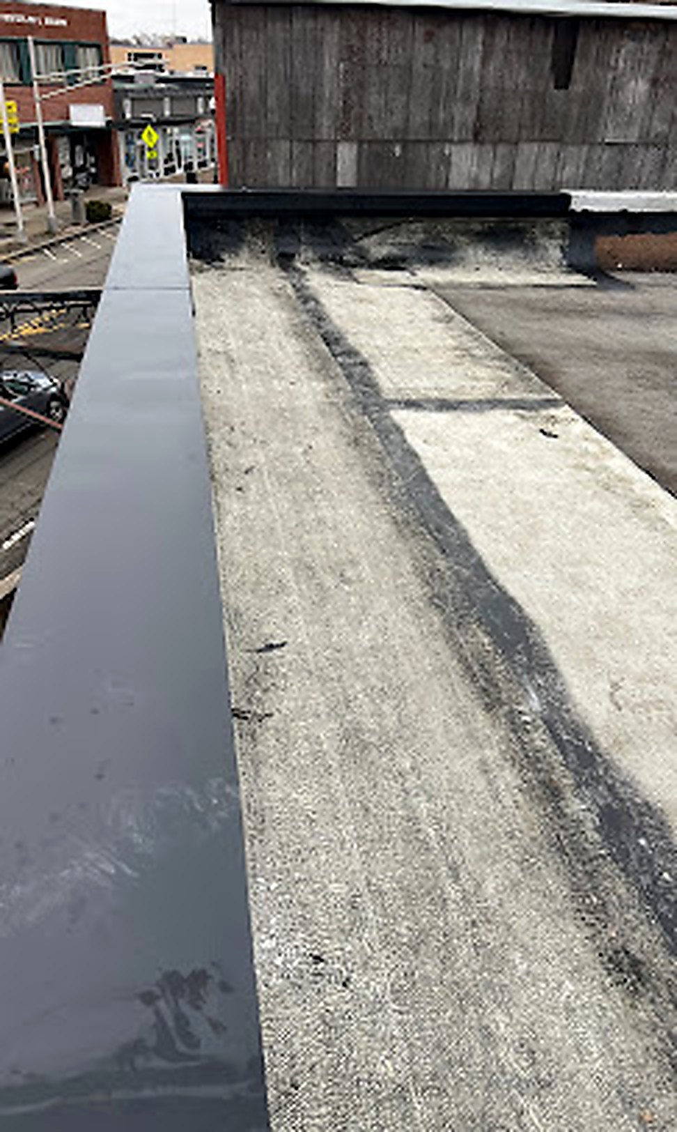 Flat commercial roof with gray metal parapet cap